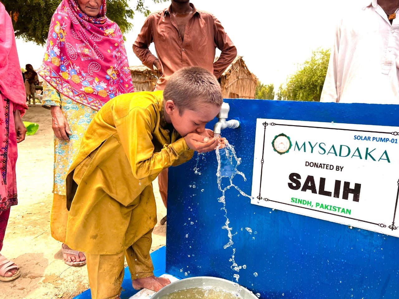 Enfant buvant l'eau propre d'un puits au Pakistan